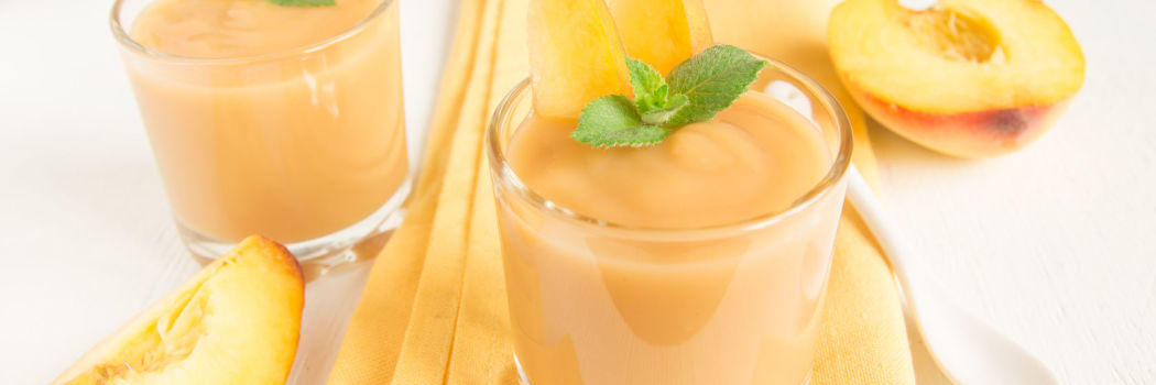 Top view of a peach smoothie with mint on a napkin