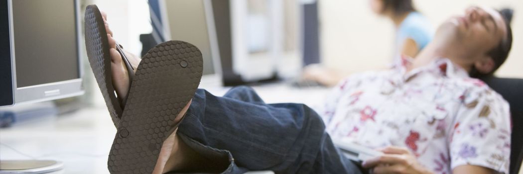 Man with his feet on his desk falling asleep at work