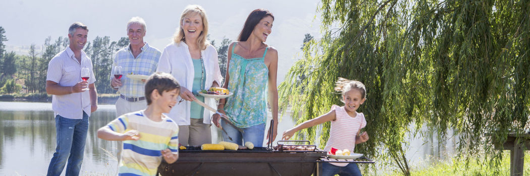 family having a barbecue together at a lake