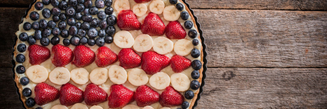 blueberries, strawberries, and bananas arranged in a pie to look like an american flag