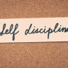 self discipline spelled out in cursive and pinned to a cork board